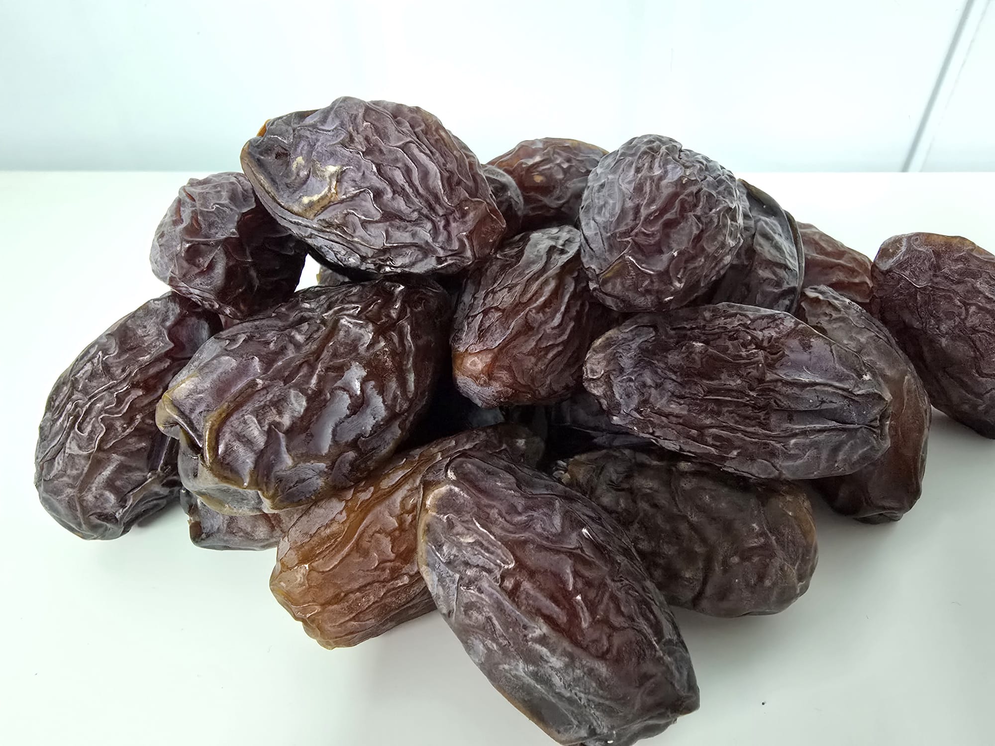 A pile of real jumbo Medjool dates showing natural sugar bloom